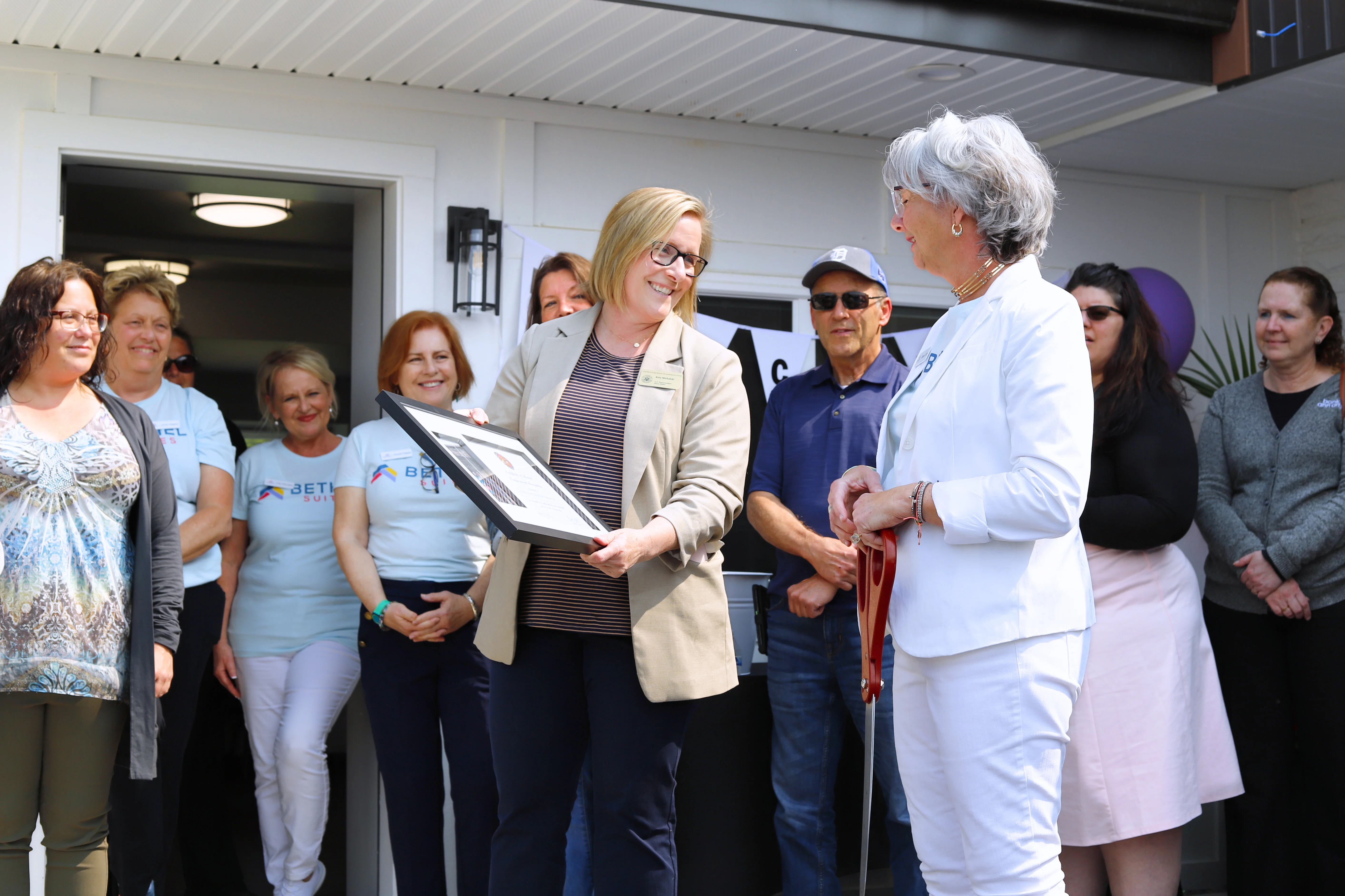 Presenting a certificate at the Bethel Suites ribbon cutting
