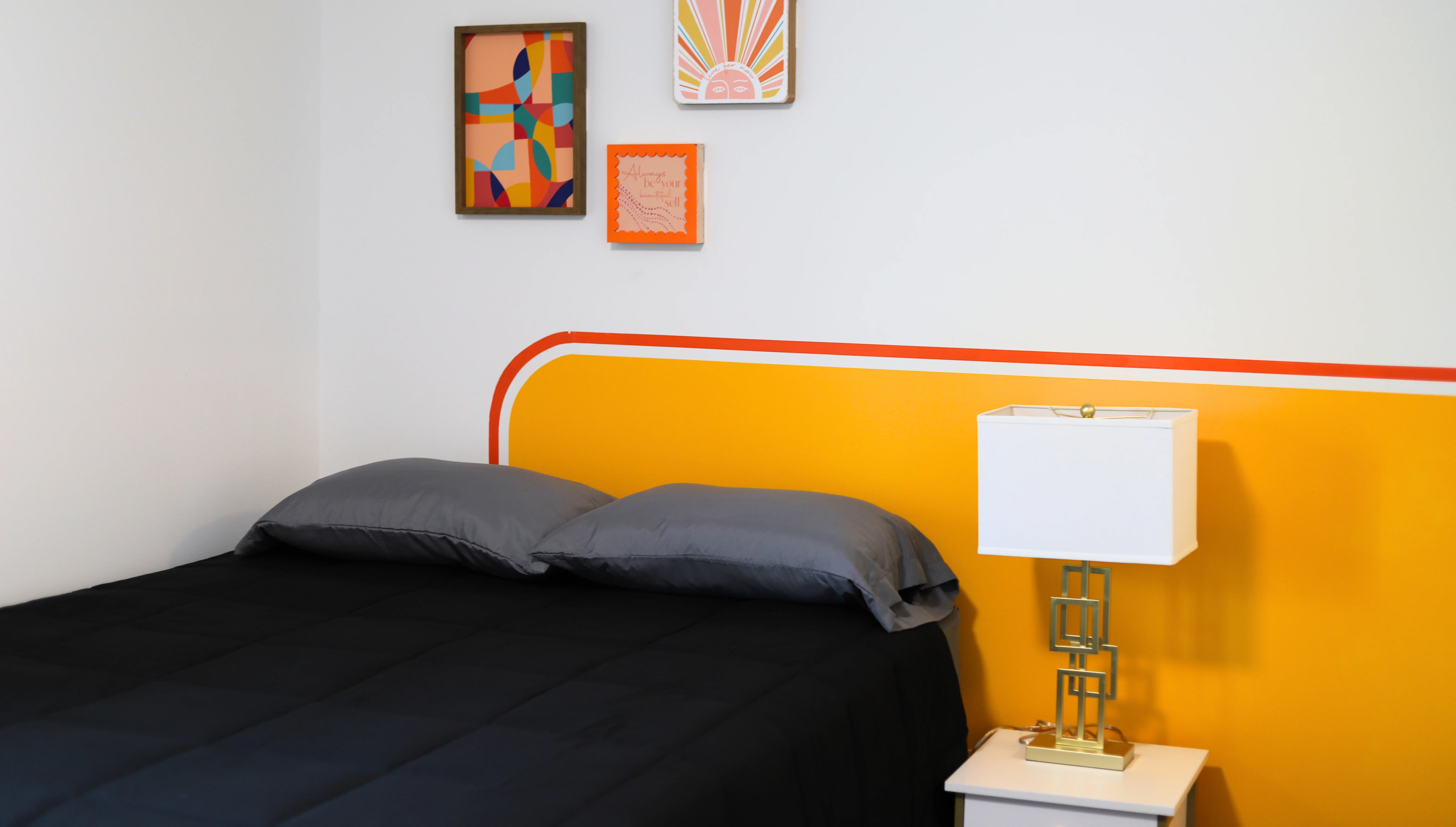 A furnished bedroom with a cheerful accent wall