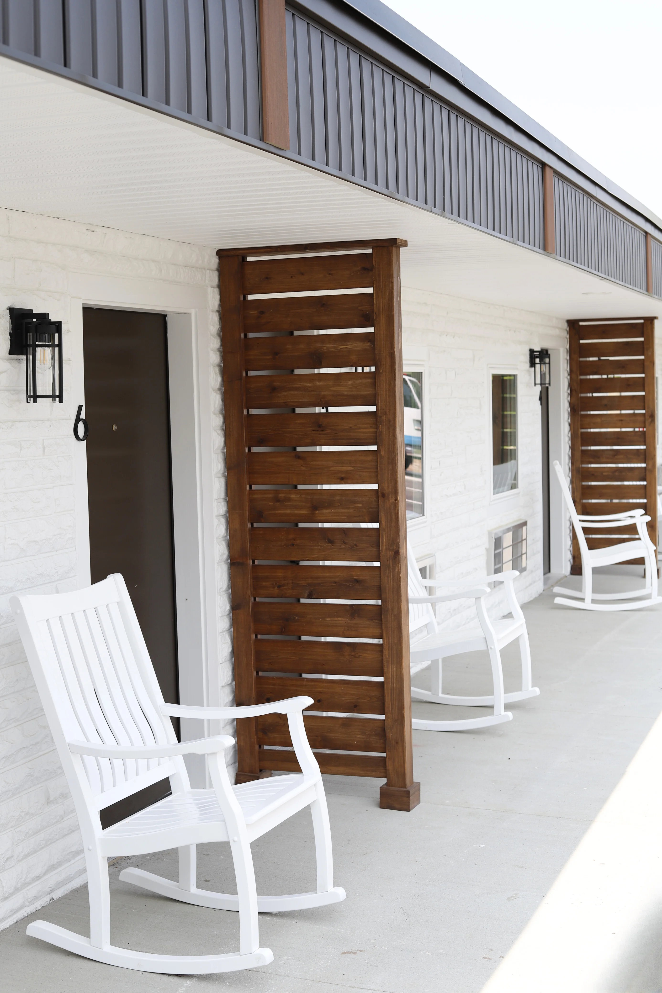 Rocking chairs line the covered porch outside the units