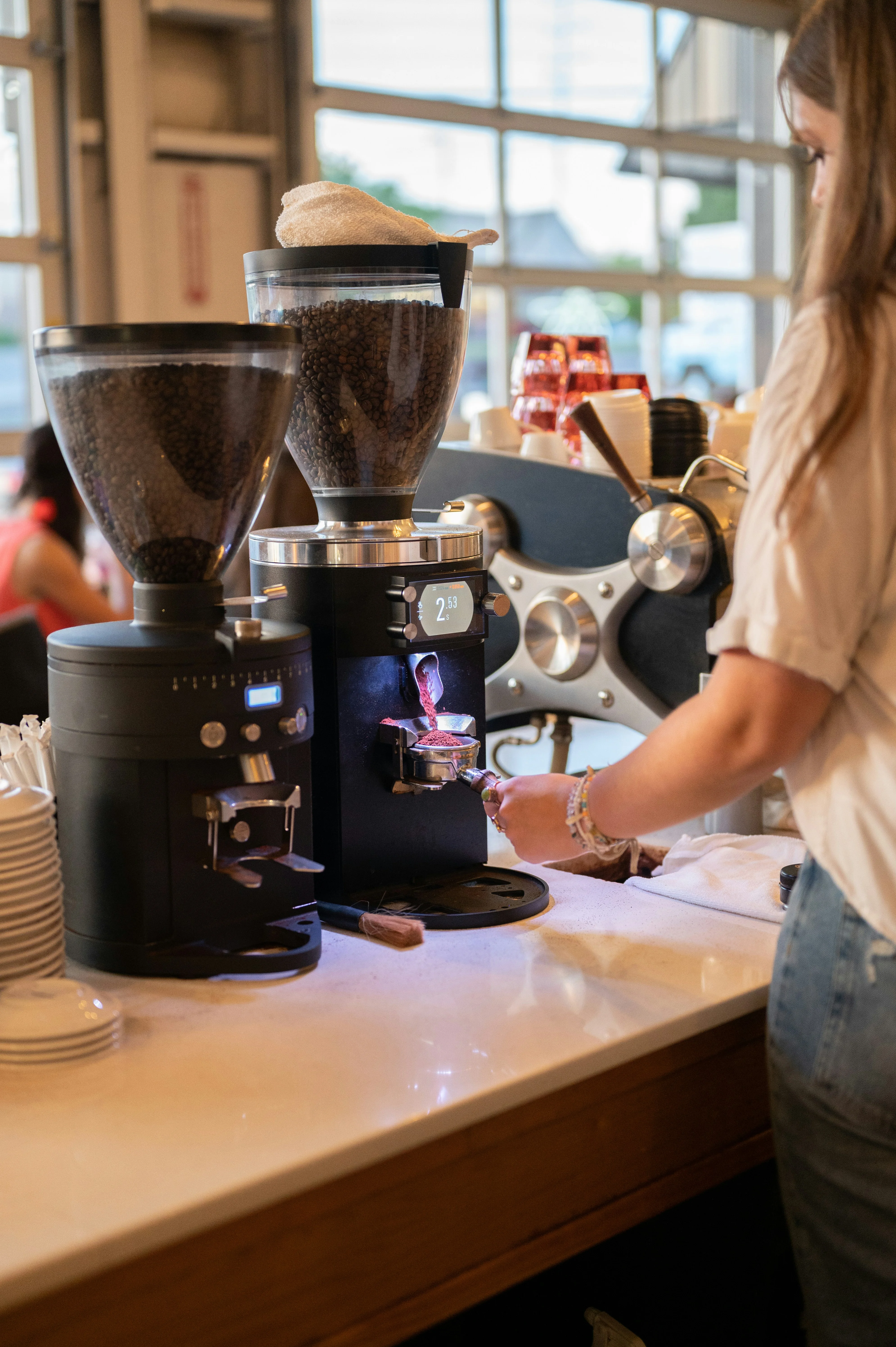 A young barista pulling espresso shots behind a coffee shop counter