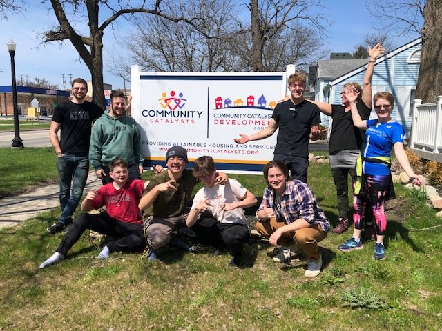 Youth volunteers at the Community Catalysts sign